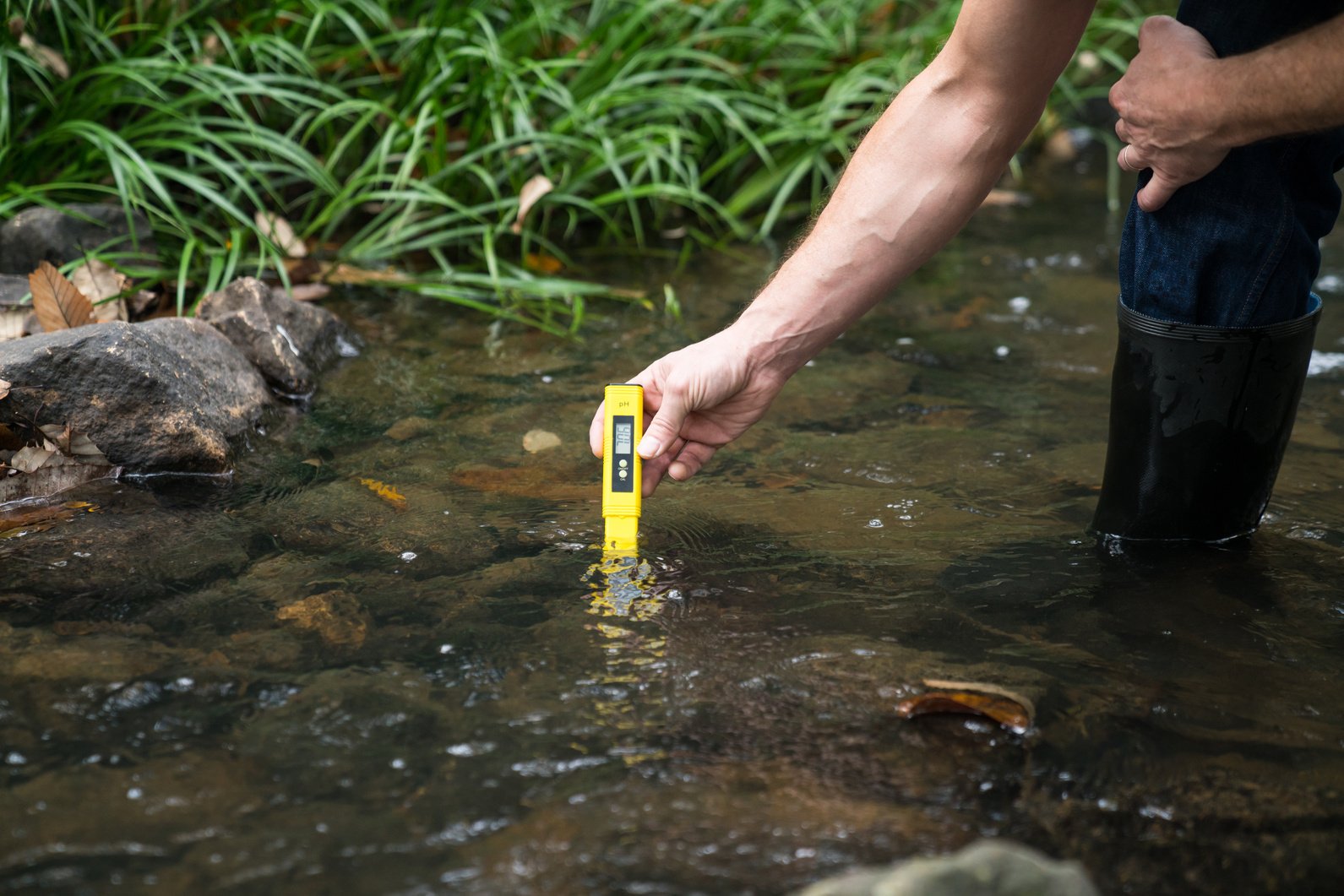 An environmental engineer or researcher checking the water with an alkaline monitor